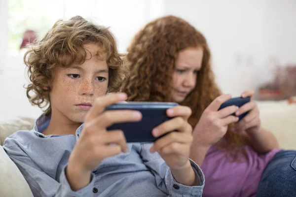 Siblings Playing Handheld Computer Game Couch — Stock Photo, Image