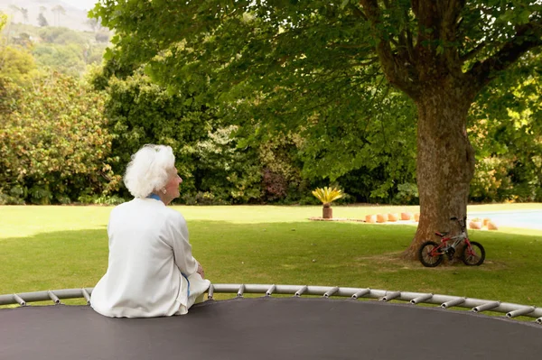 Eine Seniorin Sitzt Auf Einem Trampolin — Stockfoto