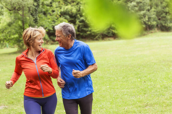 Couple running together outdoors, laughing
