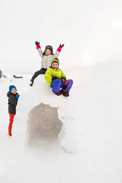 Dwoje Dzieci Siedzących Igloo Chłopiec Stojący Obok Niego — Zdjęcie stockowe