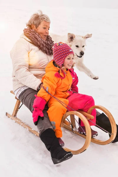 祖母と孫娘オンTobogganで雪 — ストック写真