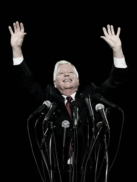Politician with hands raised isolated on black background