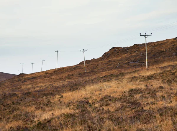 Fila de torres eléctricas en el paisaje remoto, Highlands Noroeste, Escocia, Reino Unido — Foto de Stock