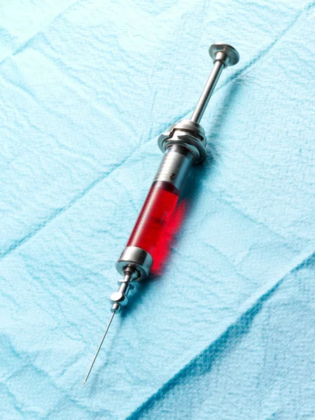 Injekční stříkačka obsahující červenou tekutinu — Stock fotografie