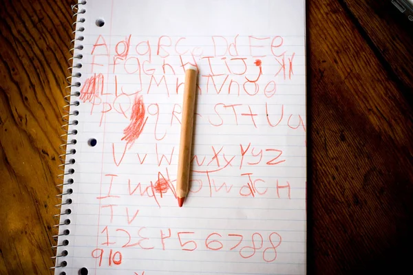 Child's writing on notepad with pencil — Stock Photo, Image