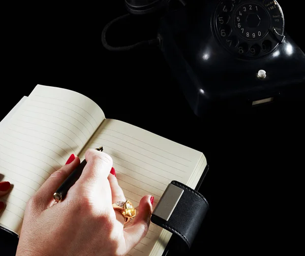 Γυναίκα Που Γράφει Στο Σημειωματάριο Μέσω Τηλεφώνου — Φωτογραφία Αρχείου