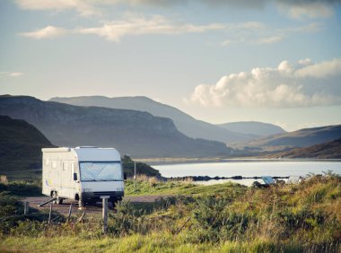 Camper van parked next to loch, Ullapool, Scotland clipart