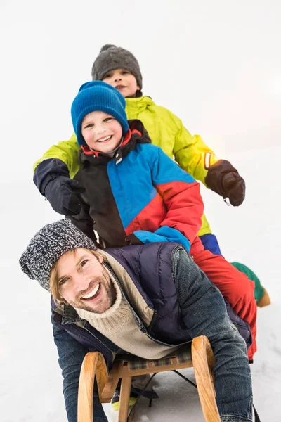 父と2人の男の子とともにトボガンで雪の中 — ストック写真