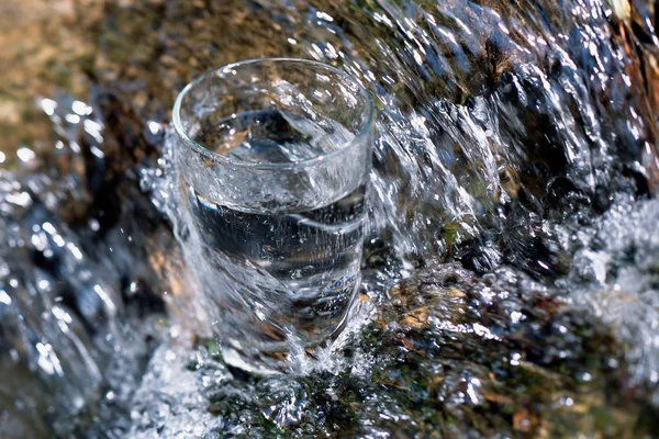 Drinking glass in stream — Stock Photo, Image