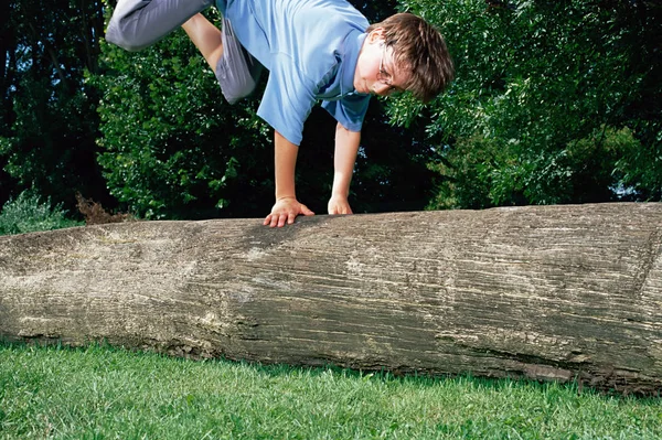 Junge Springt Über Baumstamm — Stockfoto