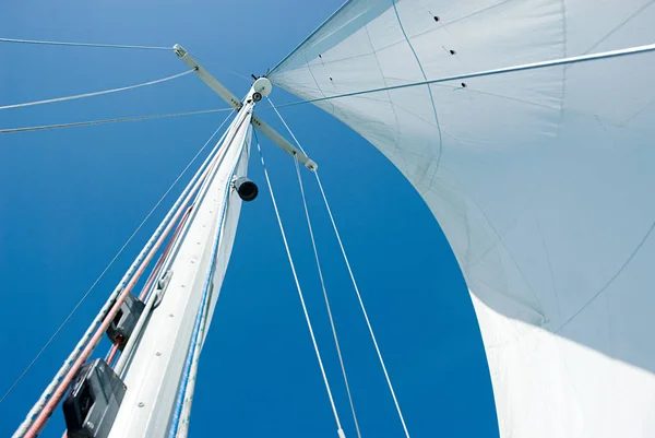 Mast and sail over sky