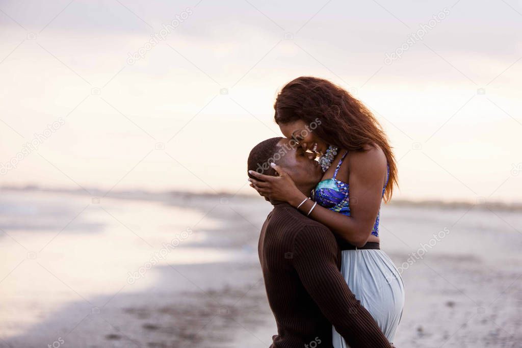 Couple on beach, hugging, face to face