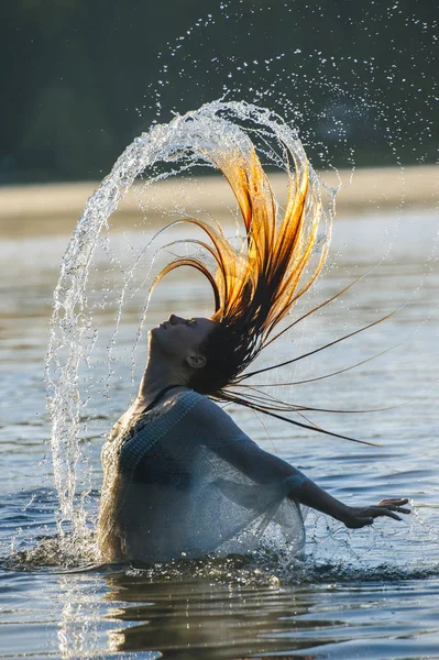 水中での若い女性のサイドビューぬれた髪の背中の腕を開く — ストック写真