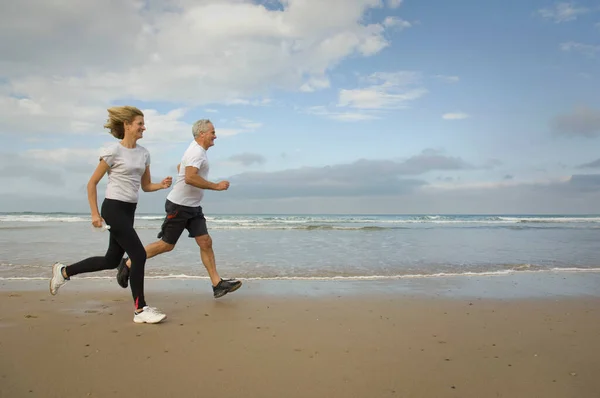 在海滩上奔跑的情侣 — 图库照片