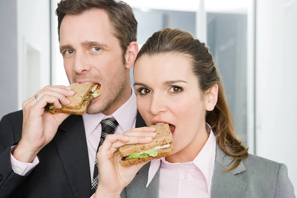 Colegas Comiendo Sándwiches Trabajando Oficina —  Fotos de Stock