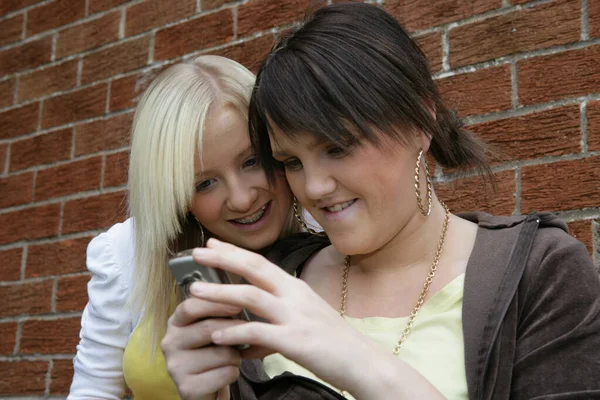 Duas Jovens Mulheres Olhando Para Telefone Móvel — Fotografia de Stock
