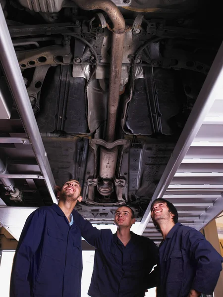Μηχανικός Που Στέκεται Κάτω Από Ανυψωμένο Αυτοκίνητο — Φωτογραφία Αρχείου