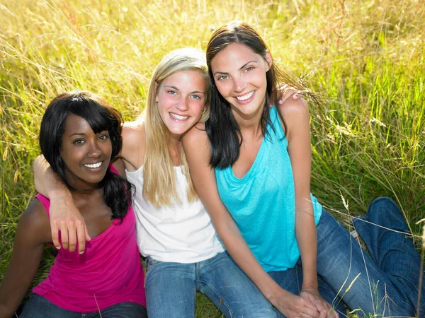 Girlfriends Seated Field Smiling — Stock Photo, Image
