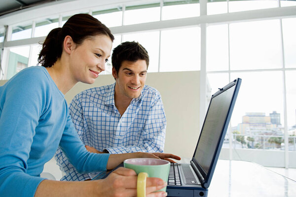 Couple using laptop at home 