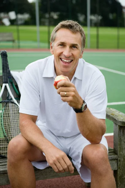 Mature man eating an apple