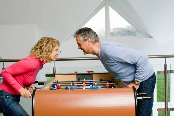 Pareja divirtiéndose jugando al fútbol de mesa — Foto de Stock