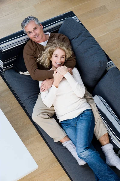 Hombre y mujer relajándose en el sofá — Foto de Stock