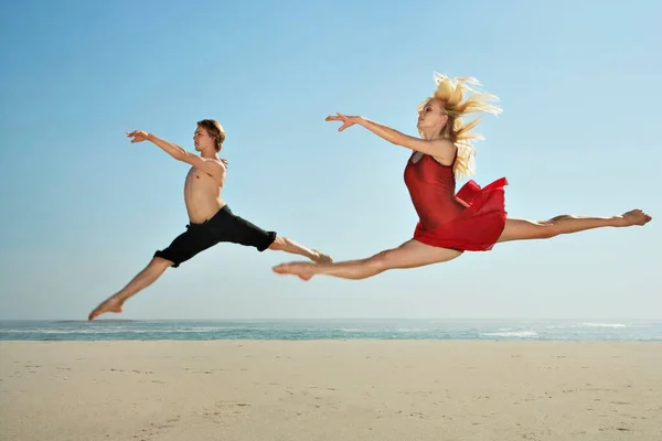 舞者在海滩上跳跃 — 图库照片