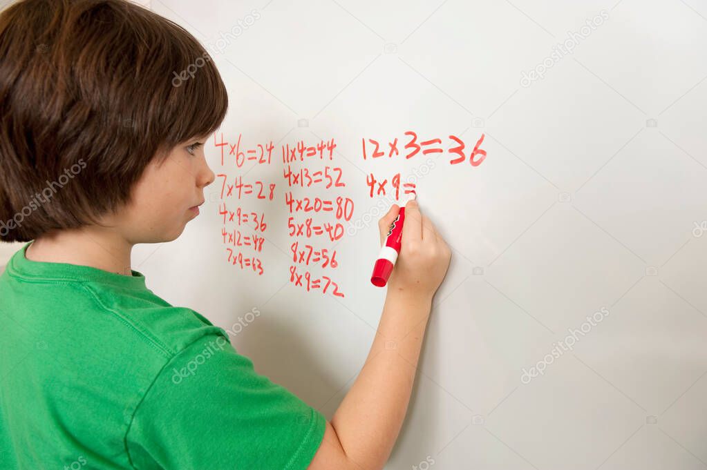 a boy writes a question mark on a white sheet