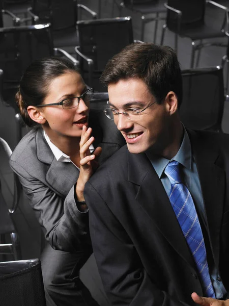 Mujer Susurrando Hombre Sentado Auditorio — Foto de Stock