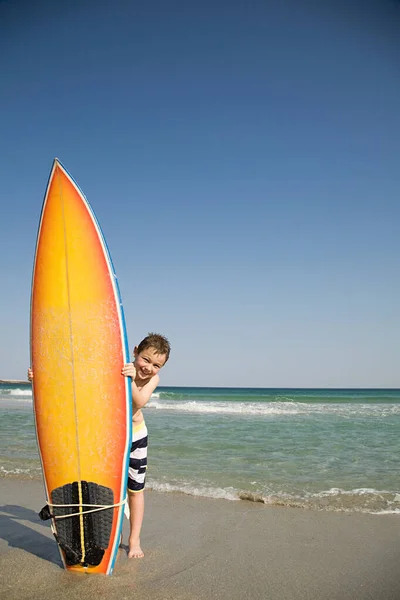 Ragazzo Tenendo Tavola Surf Sulla Sua Estremità Nella Sabbia — Foto Stock