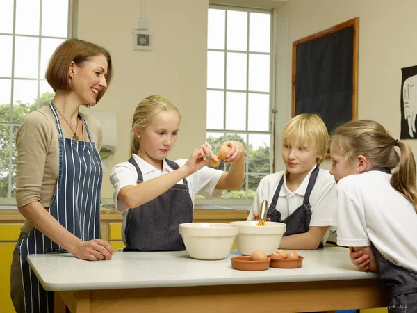 A teacher cooks with children — kuvapankkivalokuva
