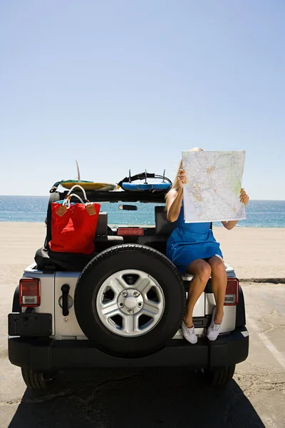 Aracın Üzerinde Oturan Genç Kadın Haritaya Bakıyor — Stok fotoğraf
