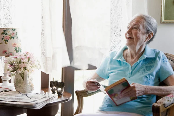 Ältere Frau Lächelt Mit Buch — Stockfoto