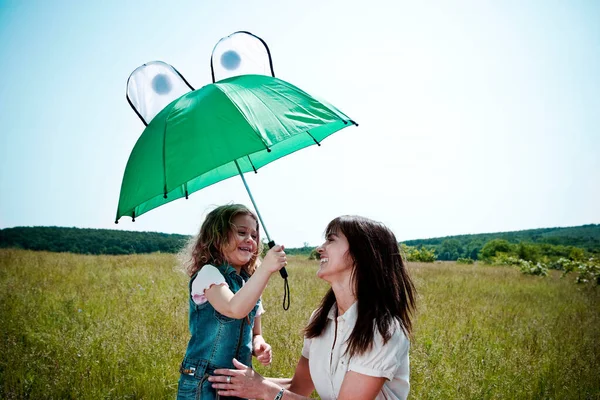 Frau und Mädchen spielen mit Regenschirm — Stockfoto