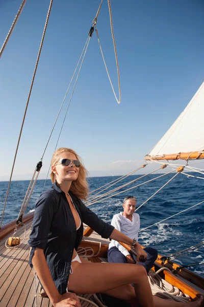couple steering a sailing boat