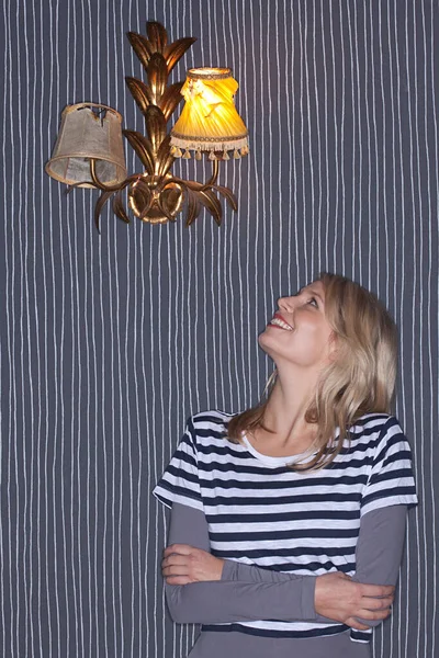 Jonge Vrouw Kijken Omhoog Naar Muur Lamp — Stockfoto