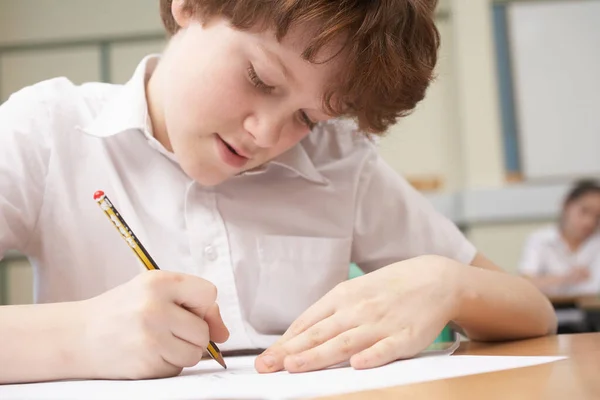 小男孩用铅笔在纸上写字 — 图库照片