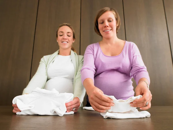 Mujeres Embarazadas Que Miran Ropa Bebé —  Fotos de Stock