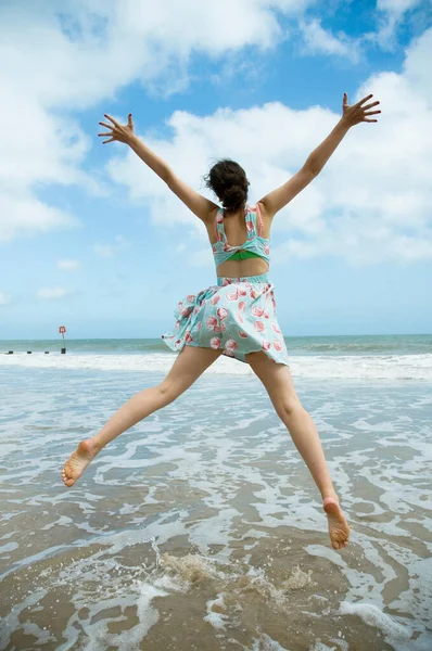 海の端で女の子の飛躍 — ストック写真