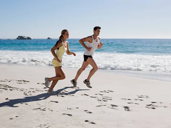 年轻夫妇在海滩上慢跑 — 图库照片