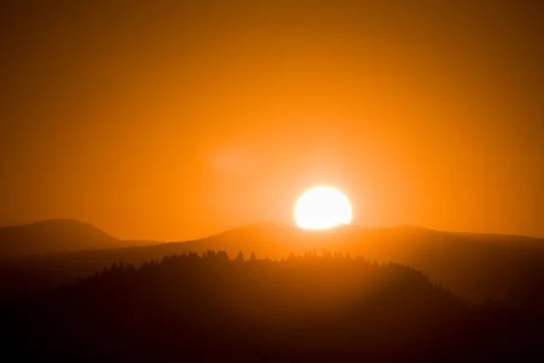 Sol saliendo sobre una montaña — Foto de Stock