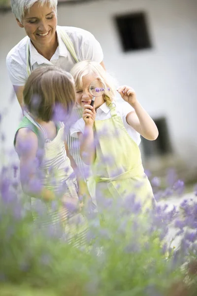 Mulher e meninas em um jardim — Fotografia de Stock