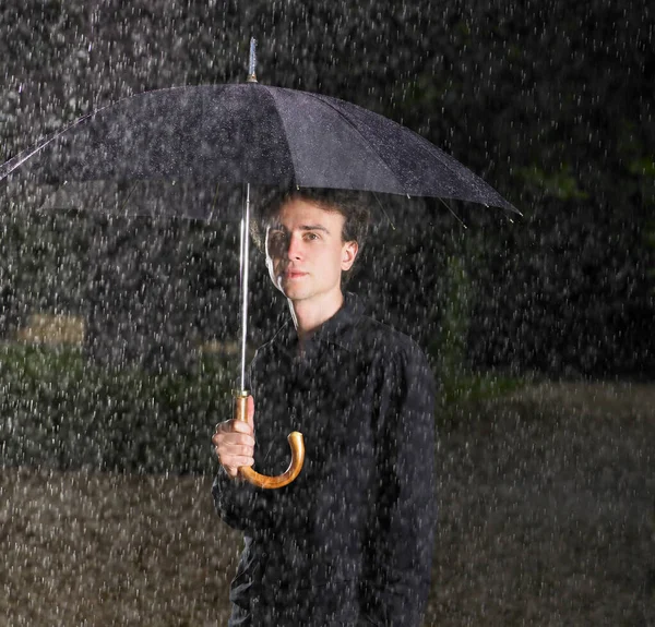 傘を持った男が雨の下で — ストック写真