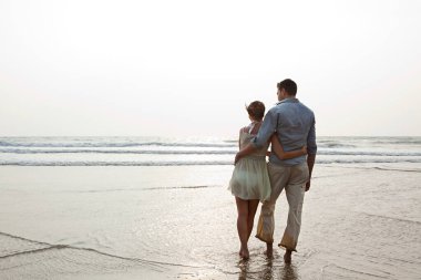 Couple looking out to the ocean clipart