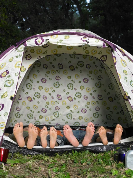 Four friends in tent, view of feet