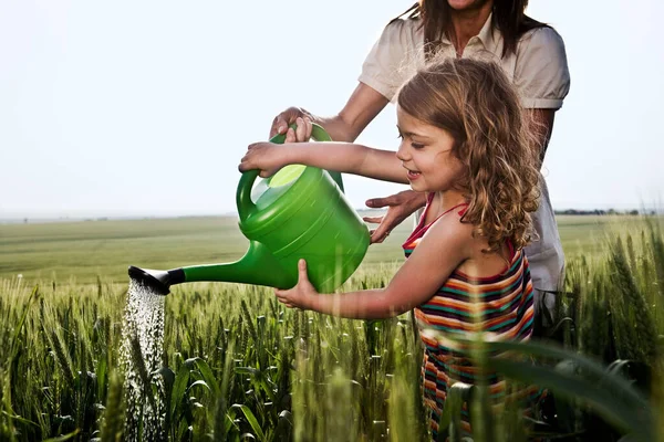 Woman and child with watering can — Stok Foto