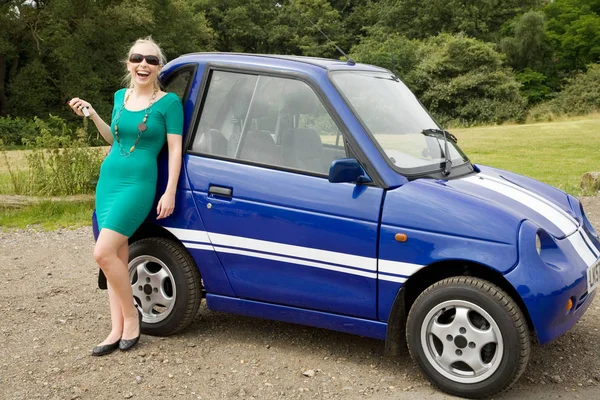 전기 자동차 앞에서 웃는 젊은 여자 — 스톡 사진