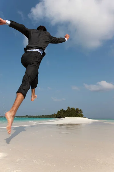 Бізнесмен стрибає на тропічному пляжі — стокове фото