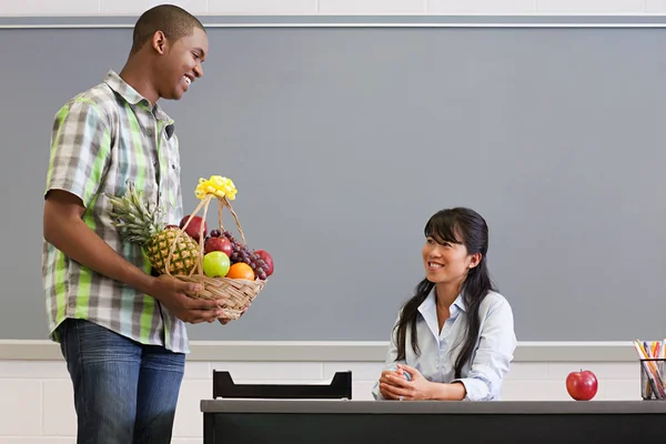 Male High School Student Giving Teacher Basket Fruit — Stock Photo, Image