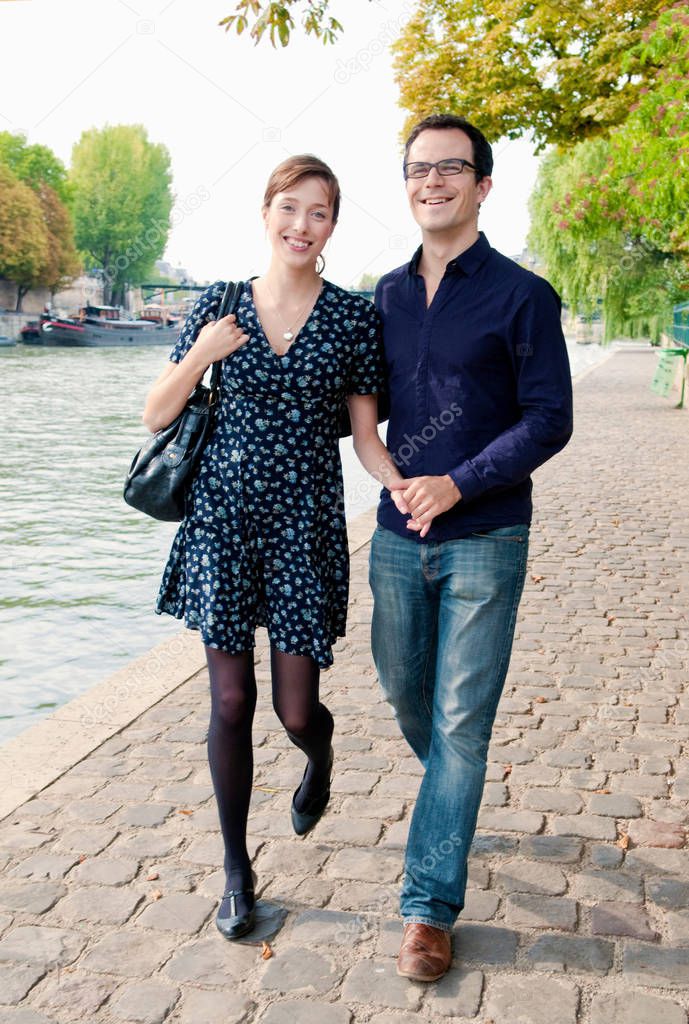 couple arm in arm by the Seine Paris